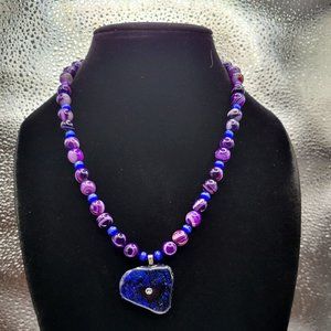 A beautiful handmade necklace with purple dichroic pendant